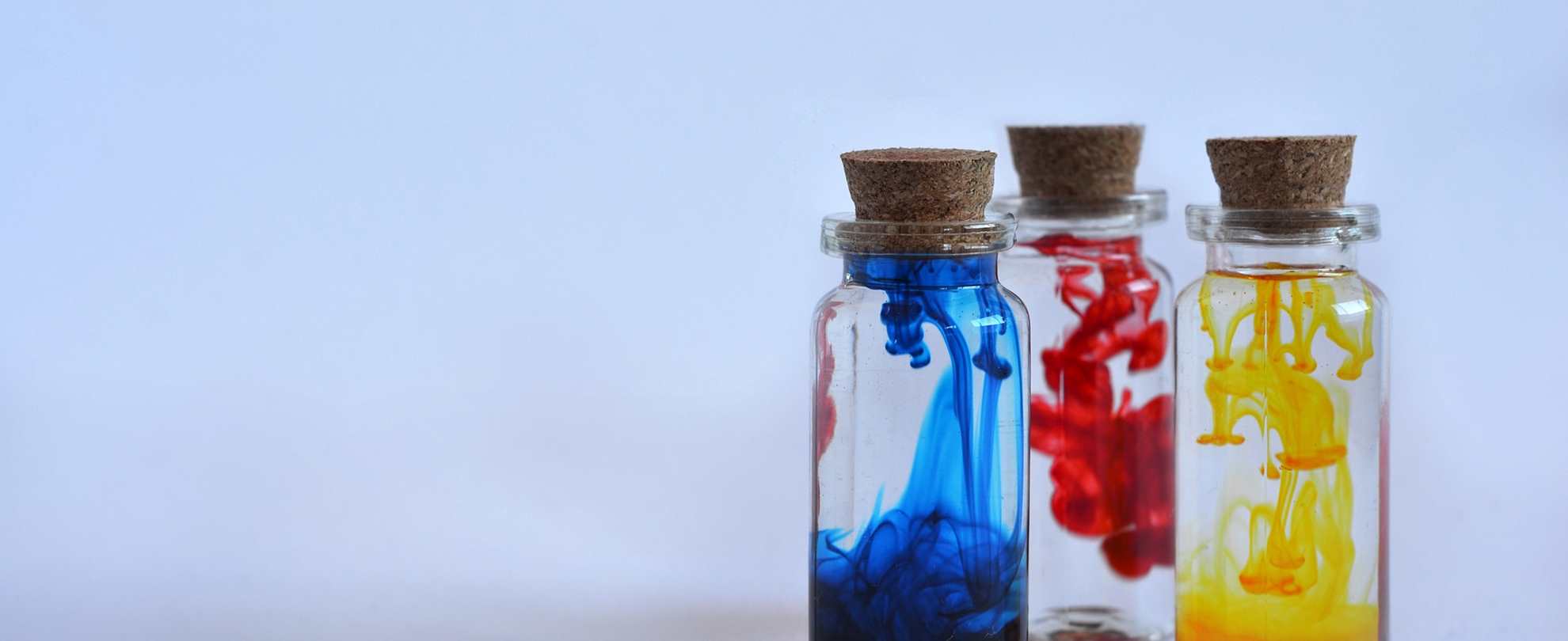 photo of 3 glass jars with blue yellow and red ink