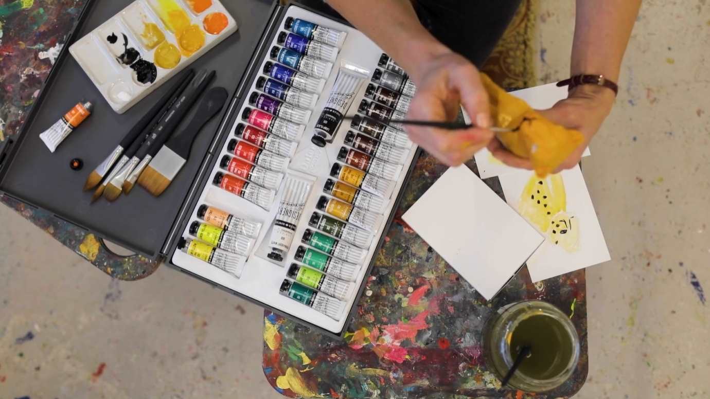 Birds eye view of Painter painting yellow leopard model using Daler-Rowney designer gouache