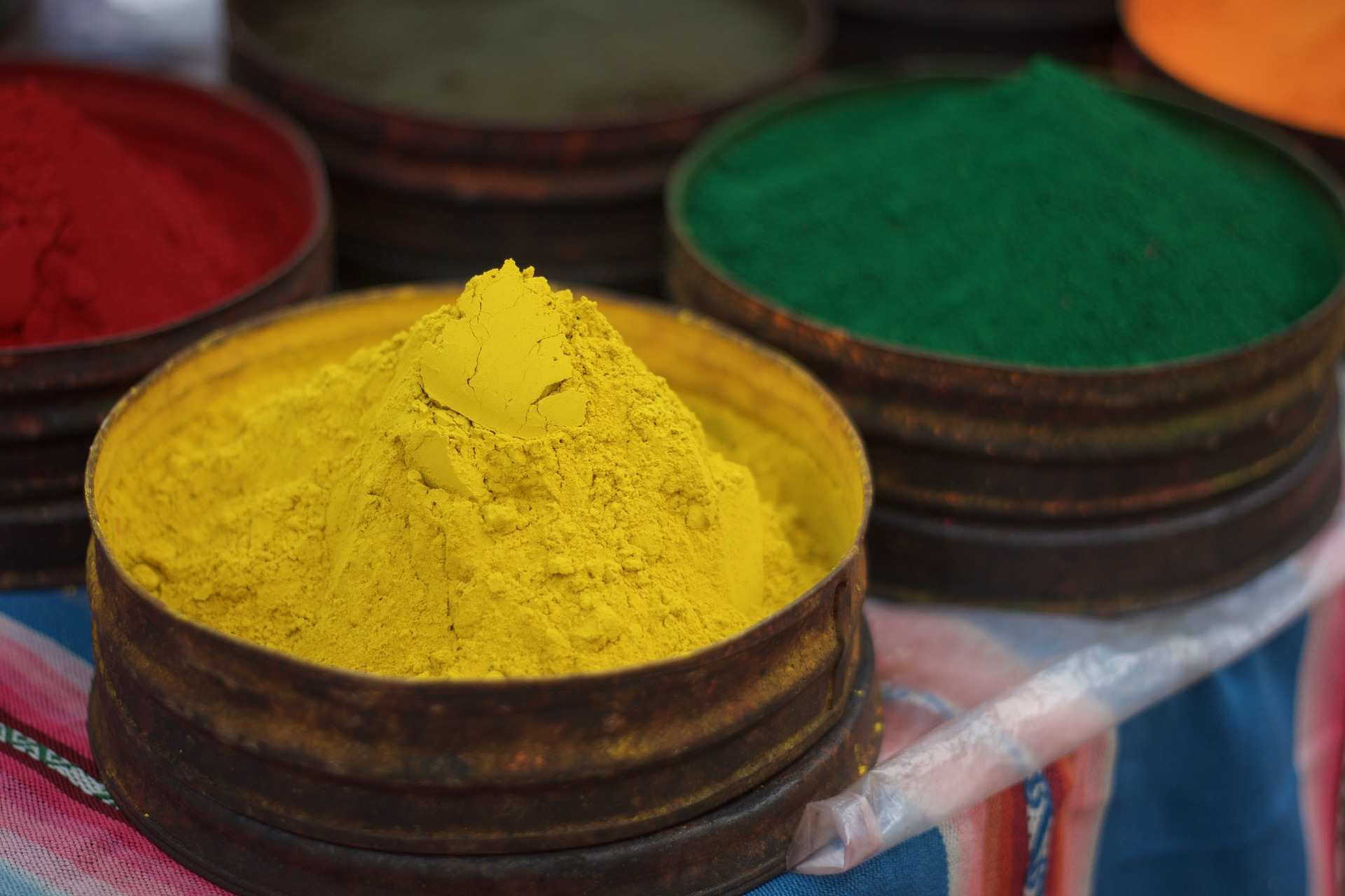 bowls of yellow red green and orange powder pigments